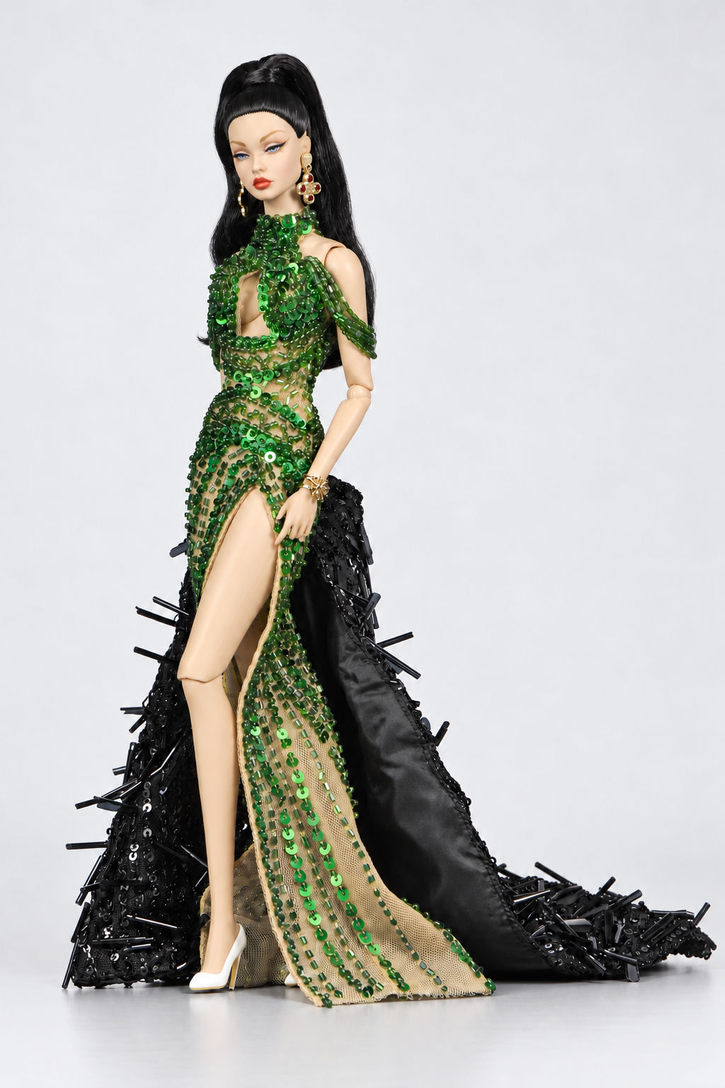 Emerald keyhole doll gown shown with the black embellished coat held at the side, revealing the coat's smooth dark lining.