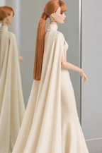 Rear side view of the ivory LE SALON cape gown, showing the high collar and the cape falling from the shoulders.