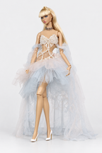 Fashion doll wearing a pearl-effect beaded bodice and pastel blue and blush high-low tulle skirt with a long airy train.