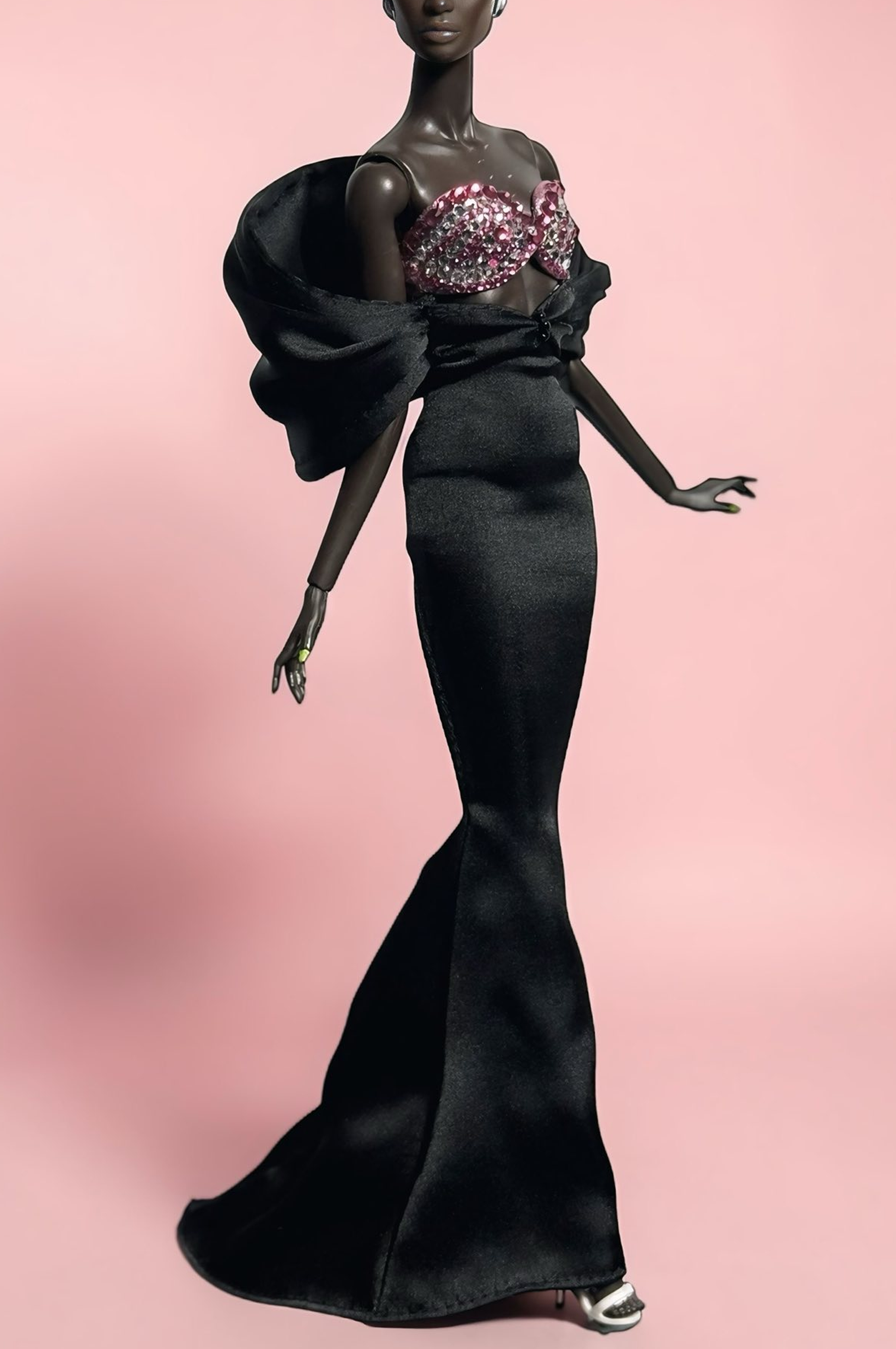 Barbie doll in a black evening gown with a pink background