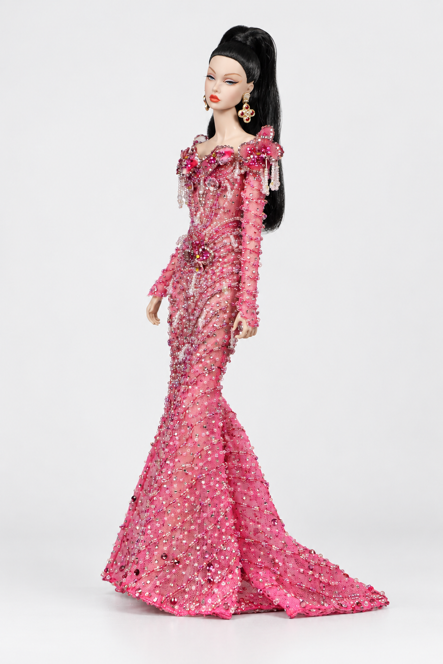 Side view of the pink beaded doll gown emphasizing the fitted waist and transition into the mermaid skirt.