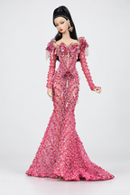Full-length fashion doll in a pink embellished mermaid gown with floral shoulder accents, long sleeves and a trailing hem.
