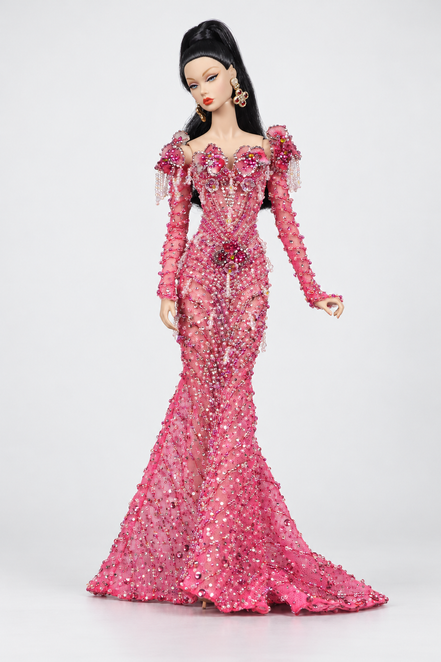 Full-length fashion doll in a pink embellished mermaid gown with floral shoulder accents, long sleeves and a trailing hem.