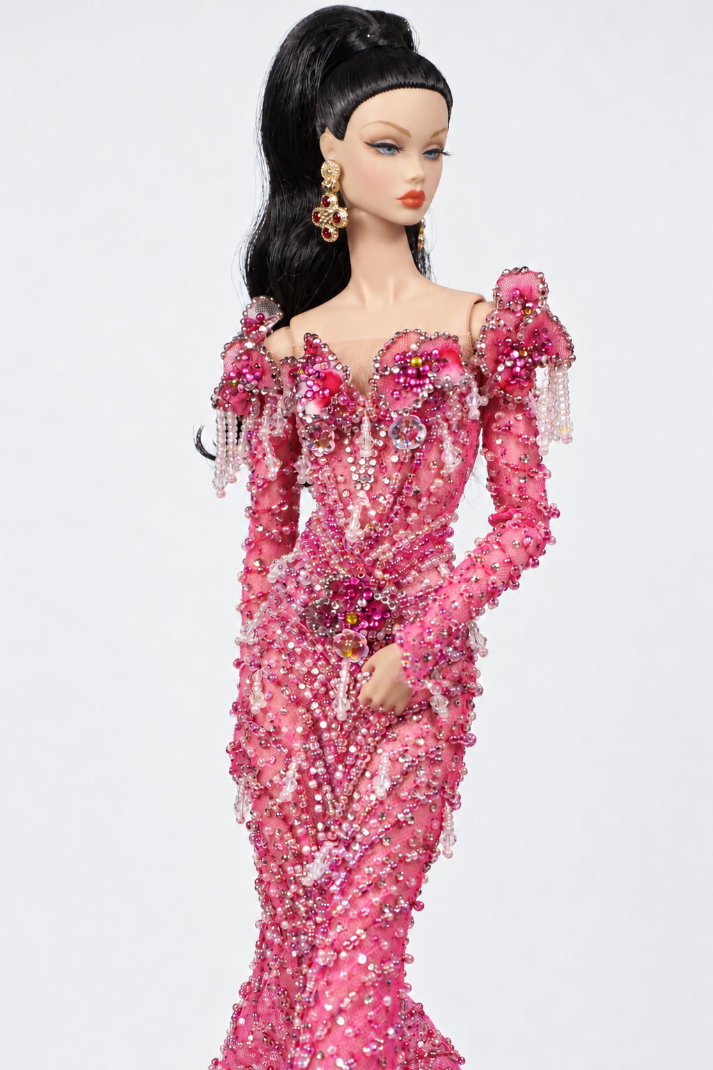 Close view of the pink gown's floral neckline and shoulders, hanging bead strands and decorated fitted sleeves.