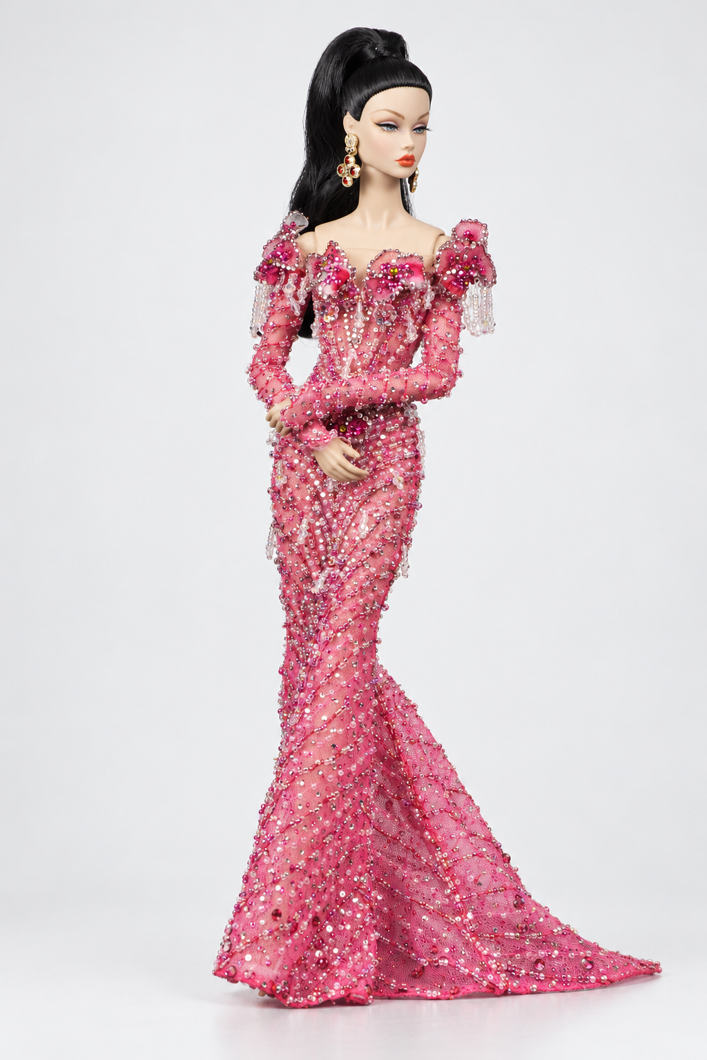 Front view of a pink mermaid doll gown showing curved bead patterns across the bodice and long decorated skirt.