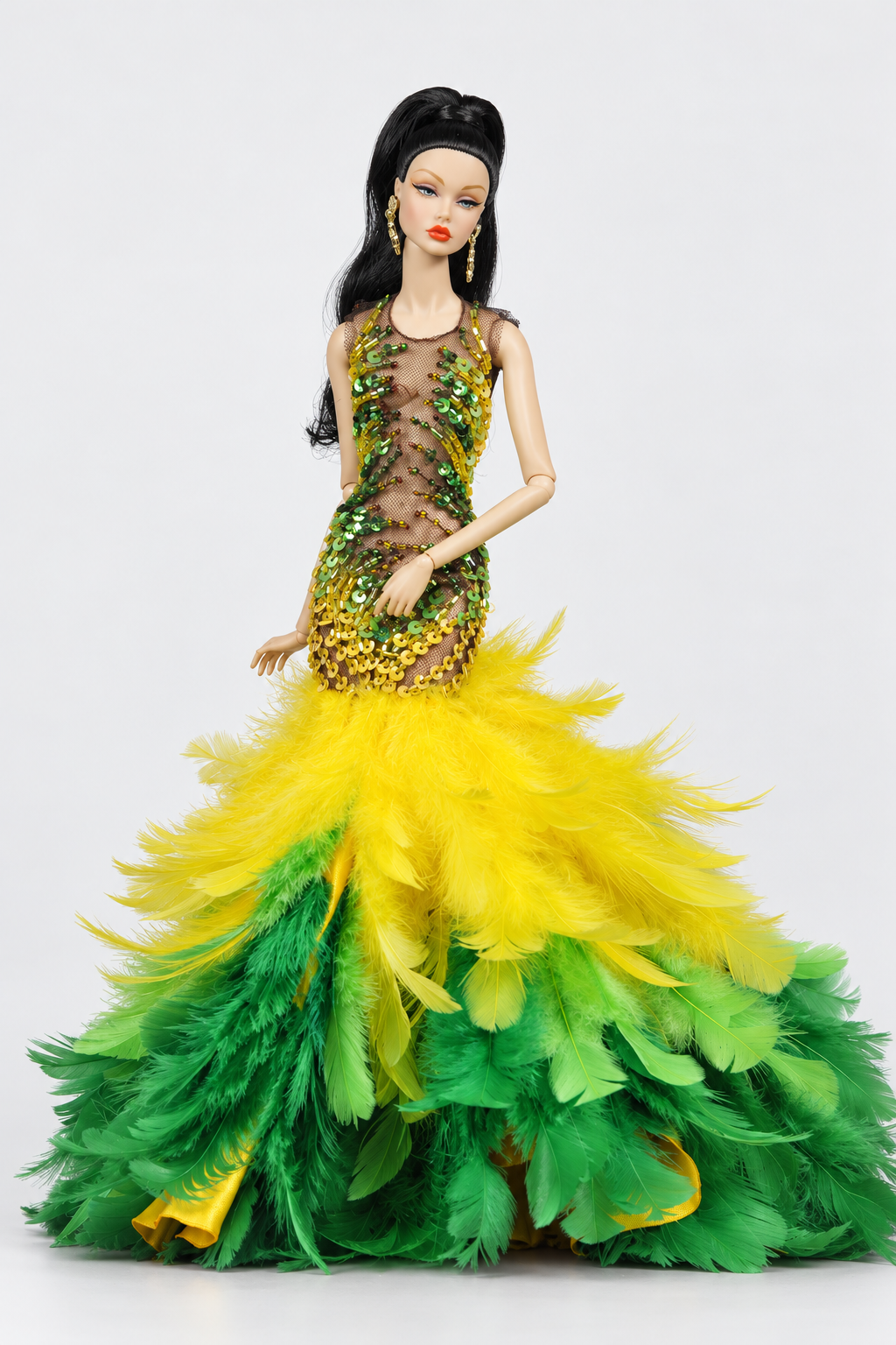 Full-length view of the feather doll gown showing the yellow transition band and dense green feathers at floor level.