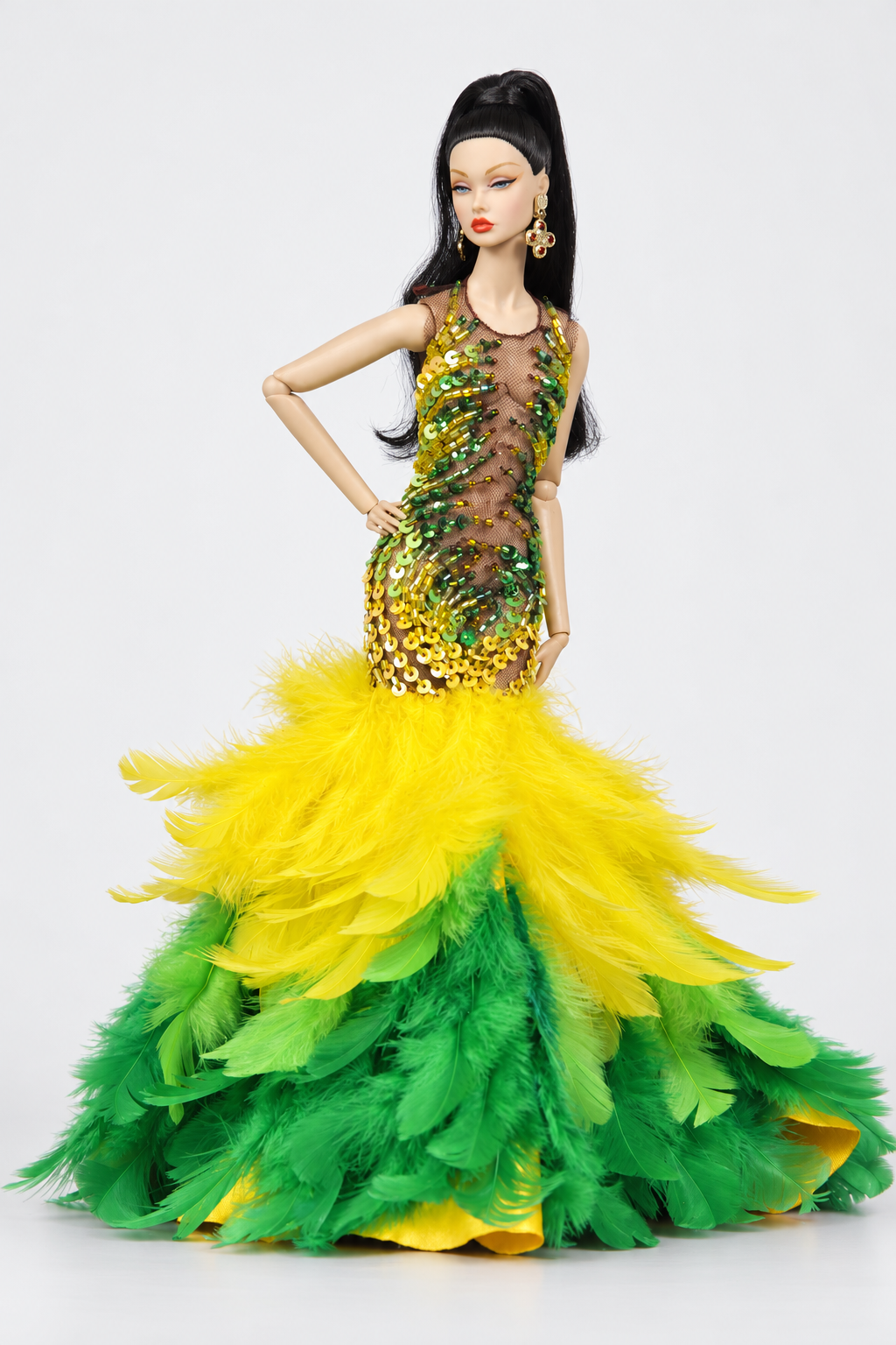 Full-length fashion doll in a green and yellow embellished mermaid gown with a wide yellow and green feather skirt.