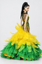 Side three-quarter view showing the fitted embellished upper gown and layered yellow and green feather flare.