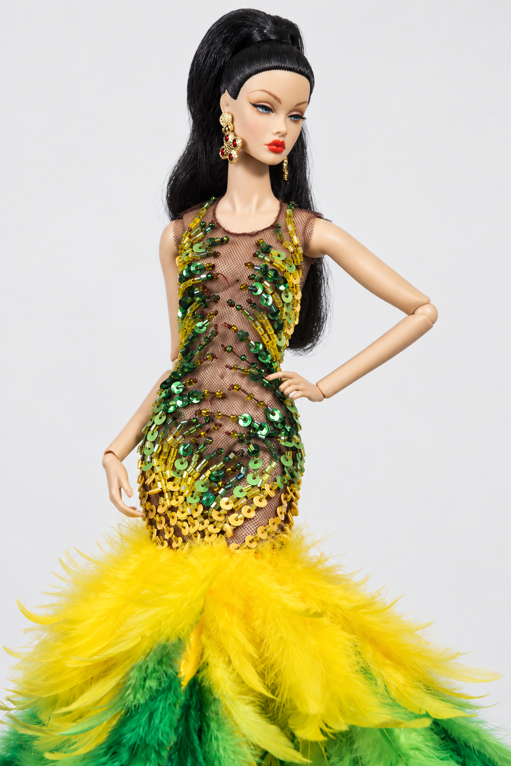 Close view of green and yellow beads and sequins on a sheer brown mesh bodice above the bright yellow feather skirt.